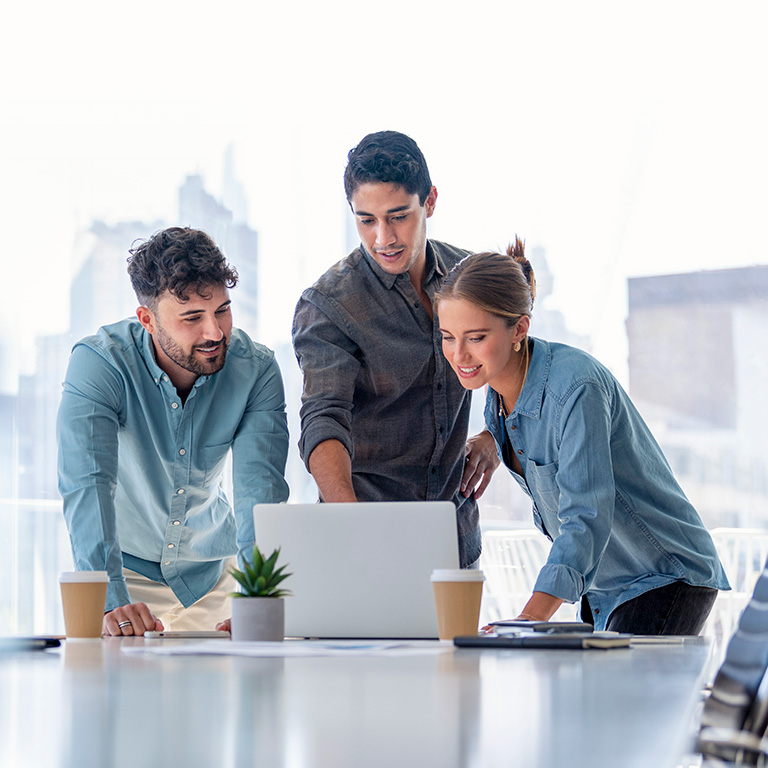 A young professional woman pointing at a visual presentation in a bright office, engaged in a strategic discussion.