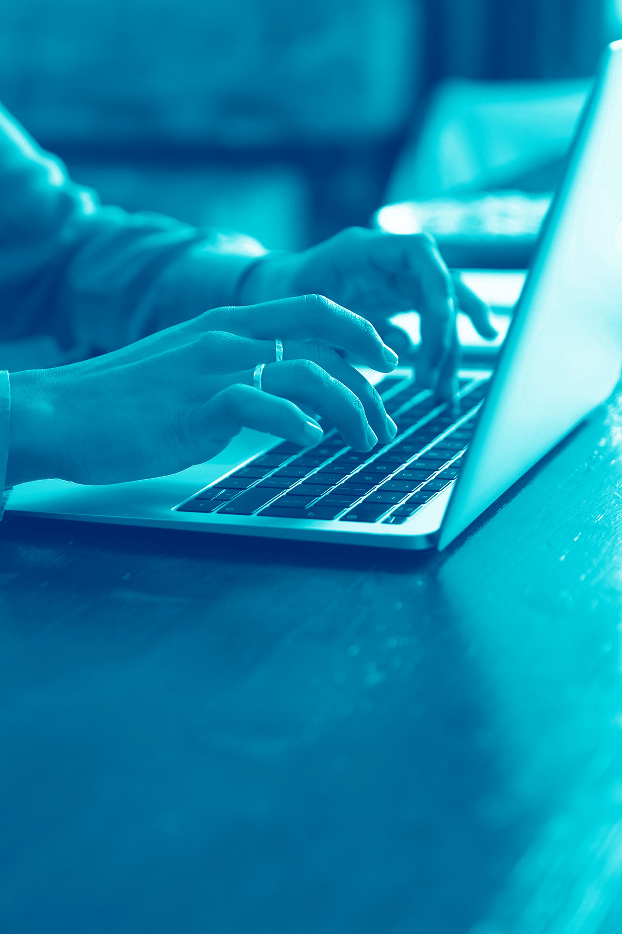 Hands of a professional working on a laptop, close-up view of the keyboard, with a focus on digital content creation.