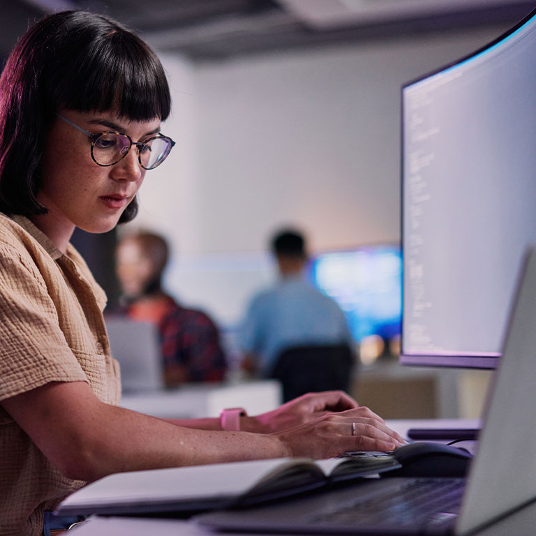 A young professional woman pointing at a visual presentation in a bright office, engaged in a strategic discussion.