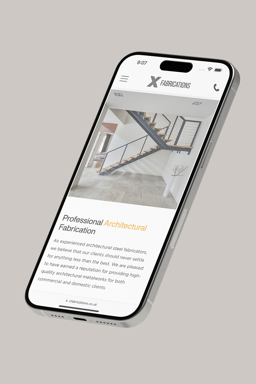Smartphone displaying a website for a fabrication company, featuring an interior image of a staircase with text about architectural steel fabrication services.